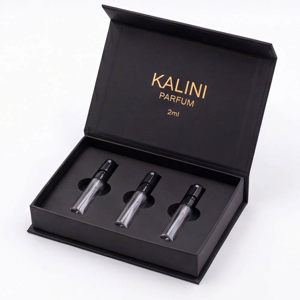 Three perfume sample vials in an open black hinged box